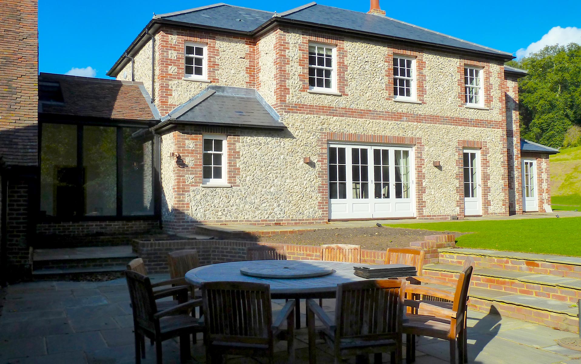 Rear view from sunken terrace area showing glass link between new house and barn